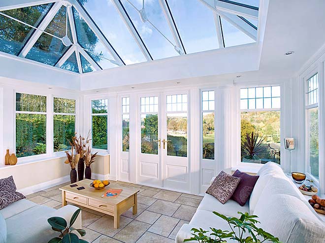 Inside timber conservatory with furniture, garden view