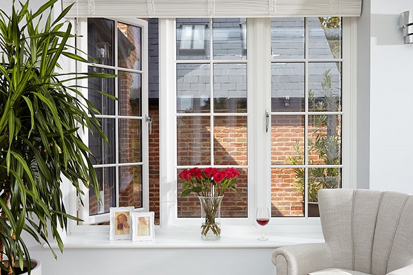 White casement windows with flowers and wine glass on ledge