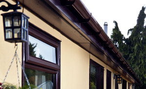 Bungalow featuring dark woodgrain fasicas and soffits and brown guttering by Anglian Home Improvements myglazing ggf
