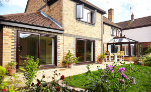 uPVC tilt & turn windows, patio doors and Victorian conservatory in Dual Dark Woodgrain by Anglian Home Improvements ggf myglazing