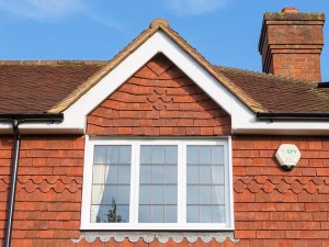 white rooftrim above white framed windows with chimney