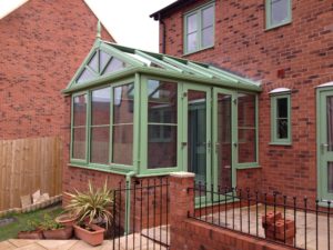 green gable fronted conservatory with brick dwarf wall