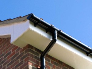 white rooftrim and black guttering with blue sky background