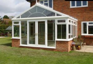 gable fronted conservatory on two storey brick house with french doors
