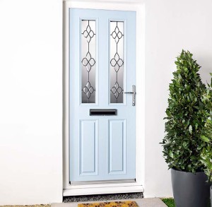 light blue front door with leaded glass and potted tree