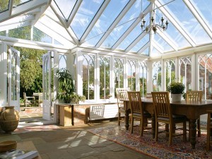 Sunny conservatory interior with dining table and rug