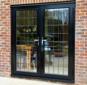 black framed french doors surrounded by bricks