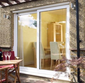 Patio sliding door with outdoor furniture, wine glasses and plant