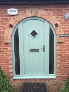 Teal front door within arched brick frame