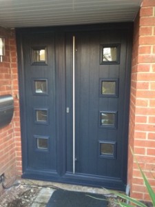 Grey blue front door framed by red brick