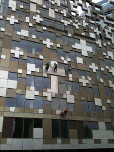 Glass repair professionals abseiling down commercial office building