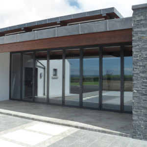 bifold doors in modern home with schist and wooden materials