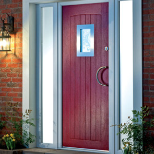 red front door with grey framework and lantern light on brick wall