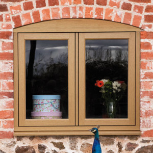 timber effect windows set in brick wall with peacock head