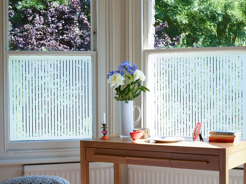 Window film on windows, table with flower vase