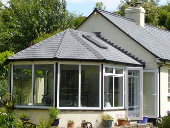 victorian conservatory with grey tiled roof by just windows and doors